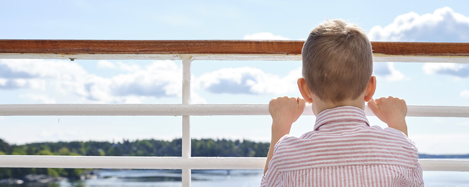 Poika katselee laivan kannella merelle